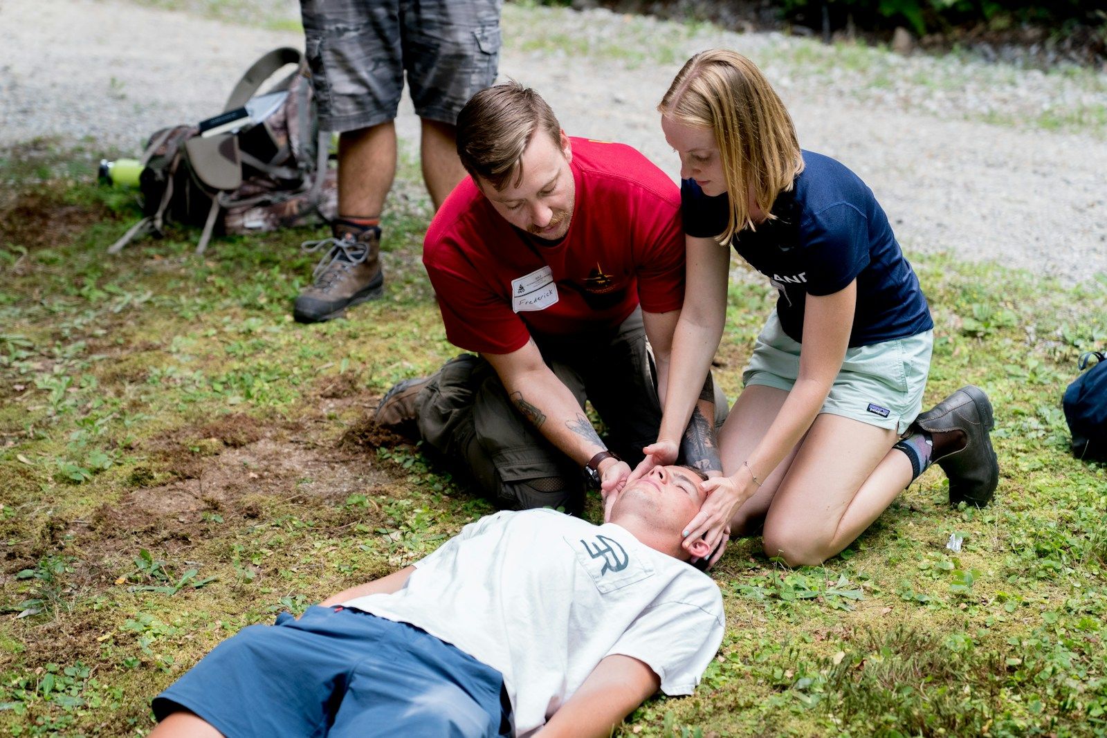 Man teaching cpr on a dummy in outdoor setting